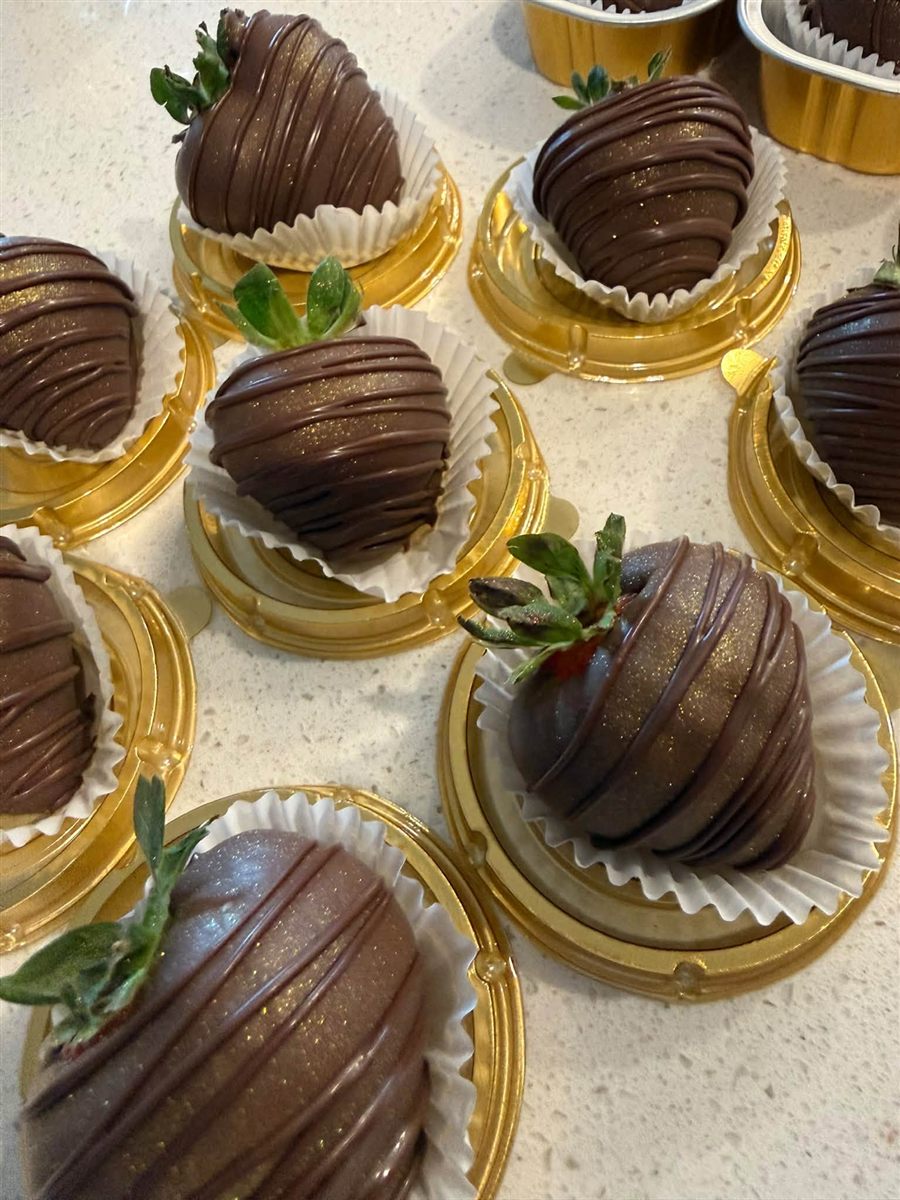 Chocolate-dipped strawberries with gold shimmer in gold cups